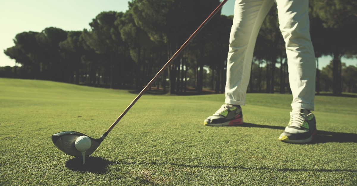 Golf player placing ball on tee